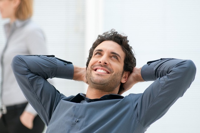 Happy smiling businessman looking up with dreaming expression at office