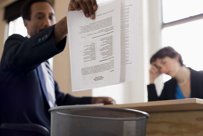 Businessman throwing away report into trash